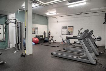 A gym with treadmills, exercise balls, and weightlifting equipment.