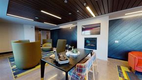 Minneapolis apartment for rent - A modern dining room with a wooden table and chairs at The Bessemer at Seward Commons Apartments, Minnesota