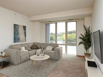 St. Paul apartment for rent - A living room with a grey sofa and a painting on the wall.
