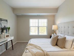 White Bear Lake apartment for rent - A bedroom with a large bed and a window with blinds at The Barnum Apartments, White Bear Lake