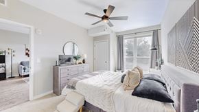 Mahtomedi apartment for rent - A bedroom with a large bed and a ceiling fan.