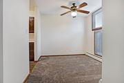 Bloomington apartment for rent - an empty living room with a ceiling fan and a window
