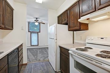 Bloomington apartment for rent - a kitchen with white appliances and brown cabinets and a white refrigerator
