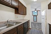 Bloomington apartment for rent - a kitchen with wooden cabinets and a sink and a refrigerator