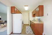 Bloomington apartment for rent - a small kitchen with a white refrigerator and wooden cabinets