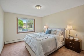 Brooklyn Park apartment for rent - a bedroom with a large bed and a large window at Point of America Apartments,Brooklyn Park