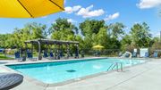 Shoreview apartment for rent - A sunny day at the pool with a yellow umbrella providing shade.