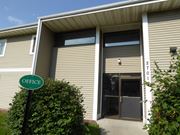 Anoka apartment for rent - A green sign with the word "OFFICE" on it is in front of a building.