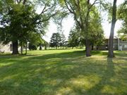 Anoka apartment for rent - A grassy area with trees and a building in the background.