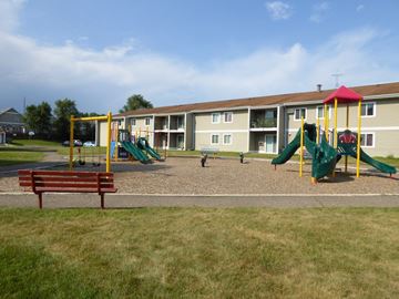 Anoka apartment for rent - A playground with a green slide and a red and yellow structure.