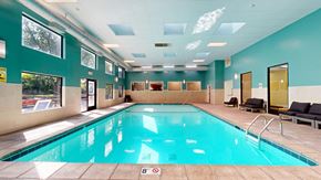 Saint Paul apartment for rent - A large indoor swimming pool with a sunny view outside.
