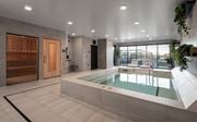 Vadnais Heights apartment for rent - A modern indoor swimming pool with a wooden door and a glass wall.