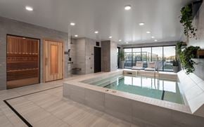 Vadnais Heights apartment for rent - A modern indoor swimming pool with a wooden door and a glass wall.