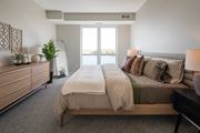 Vadnais Heights apartment for rent - A bedroom with a large bed and a dresser with a mirror.