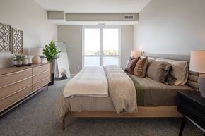 Vadnais Heights apartment for rent - A bedroom with a large bed and a dresser with a mirror.