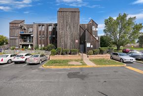 Bloomington apartment for rent - a parking lot with cars parked in front of a wooden building