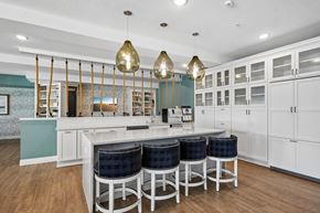 White Bear Lake apartment for rent - A kitchen with white cabinets and a bar area with blue stools.