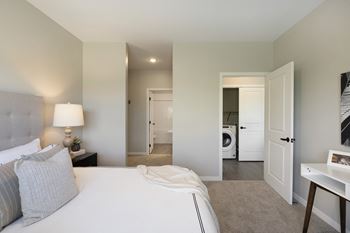 A bedroom with a bed, nightstand, and a lamp.
