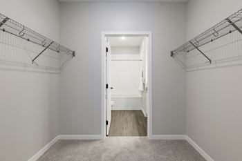 A white door is open in a room with white walls and a carpeted floor.