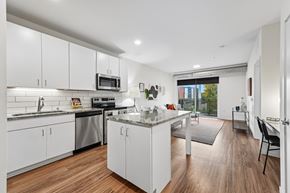 Minneapolis apartment for rent - A modern kitchen with white cabinets and a wooden floor.