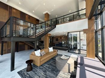 A large lobby with a staircase in the background and a couch 