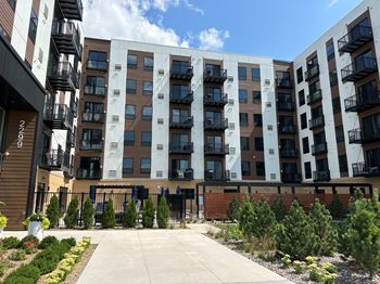 A large apartment building with a concrete walkway in front of it