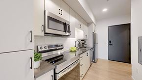 Saint Paul apartment for rent - A modern kitchen with a stove, oven, microwave, and refrigerator. at The Hill Apartments, Saint Paul, Minnesota