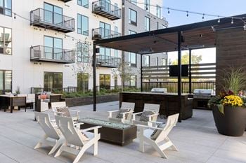 A patio with white chairs and a firepit