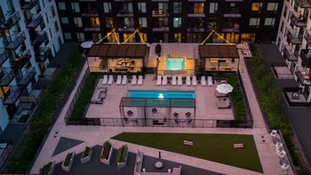 An aerial view of the pool at night in an apartment building