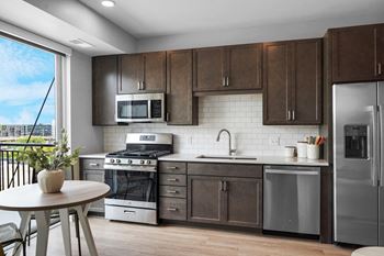 A kitchen with dark wood cabinets and stainless steel appliances