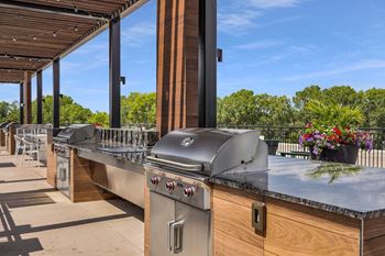 An outdoor kitchen with stainless steel appliances and a bar