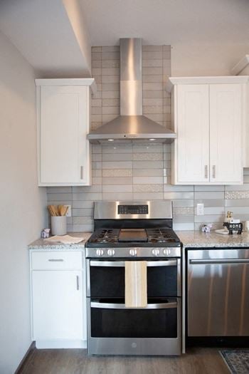 A kitchen with stainless steel appliances and white cabinets