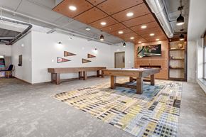 South St. Paul apartment for rent - a game room with a shuffle board table, pool table, and a flat screen tv