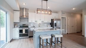 South St. Paul apartment for rent - a kitchen with white cabinets and a blue island with three stools