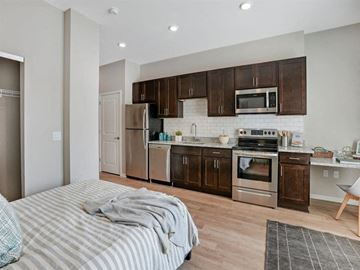 Minneapolis apartment for rent - A modern kitchen with dark brown cabinets and stainless steel appliances.