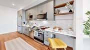 Minneapolis apartment for rent - A modern kitchen with a yellow chair and white cabinets.