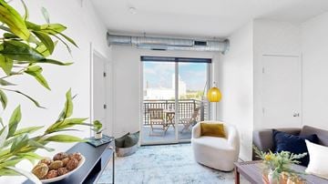Minneapolis apartment for rent - A living room with a blue carpet and a large window.