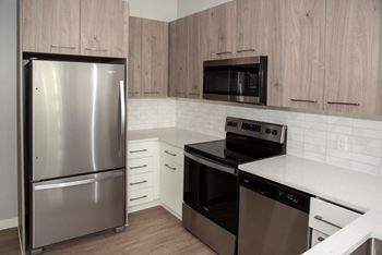 Nordic kitchen with stainless steel, quartz countertops, two-toned cabinets