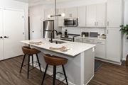 St Louis Park apartment for rent - a kitchen with white cabinets and a white island with two stools at Volo at Texa Tonka, St Louis Park, Minnesota