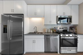 Minneapolis apartment for rent - a kitchen with stainless steel appliances and white cabinets at The Gateway at West Lake Quarter, Minneapolis, MN, 55416