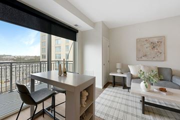 Minneapolis apartment for rent - a living room with a table and a couch and a balcony