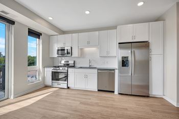 A kitchen with white cabinetry and stainless steel appliances