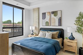 Minneapolis apartment for rent - a bedroom with a large window and a bed with blue blankets and pillows