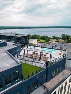 Minneapolis apartment for rent - a view of the pool area from the top of a building with a lake in the background