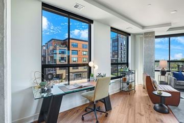 Minneapolis apartment for rent - A modern living room with a glass table and a view of the city.