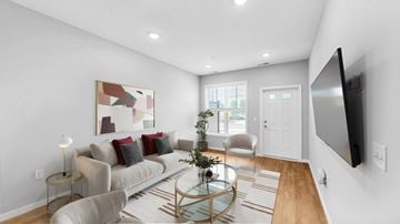 Lakeville townhouse for rent - A modern living room with a glass coffee table and a large painting on the wall.