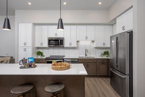 Waconia apartment for rent - A modern kitchen with white cabinets and a stainless steel refrigerator.