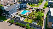 Saint Paul apartment for rent - A pool surrounded by a grassy area and a building.
