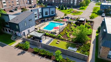 Saint Paul apartment for rent - A pool surrounded by a grassy area and a building.