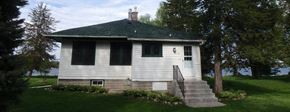 Medicine Lake apartment for rent - a small white house with stairs and a green roof